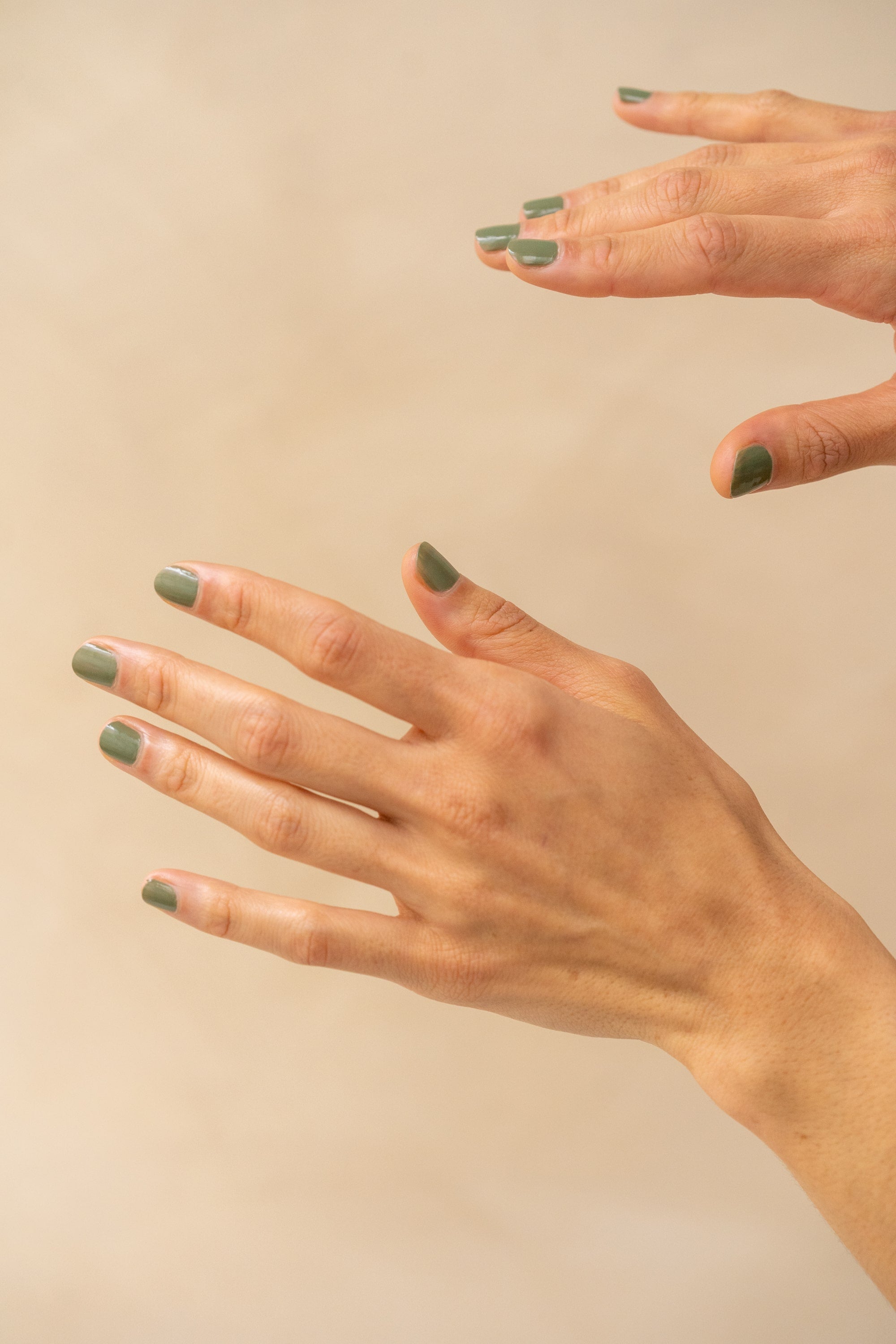 des mains montre du vernis vert